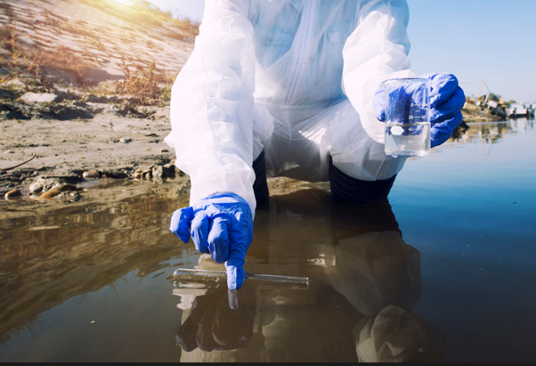Environmental scientist collecting river water samples, representing sewage pollution prevention and water contamination monitoring.