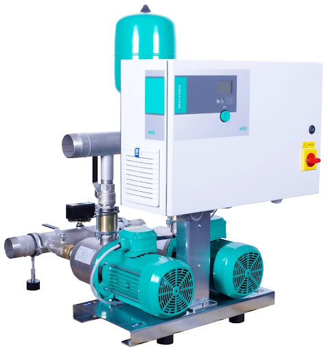 Industrial booster pump system with electric motors and control panel, highlighting the importance of hydraulic maintenance service for reliable operation.
